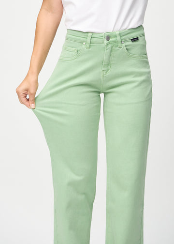 Model strækker jeansene ved låret for at vise stretch.