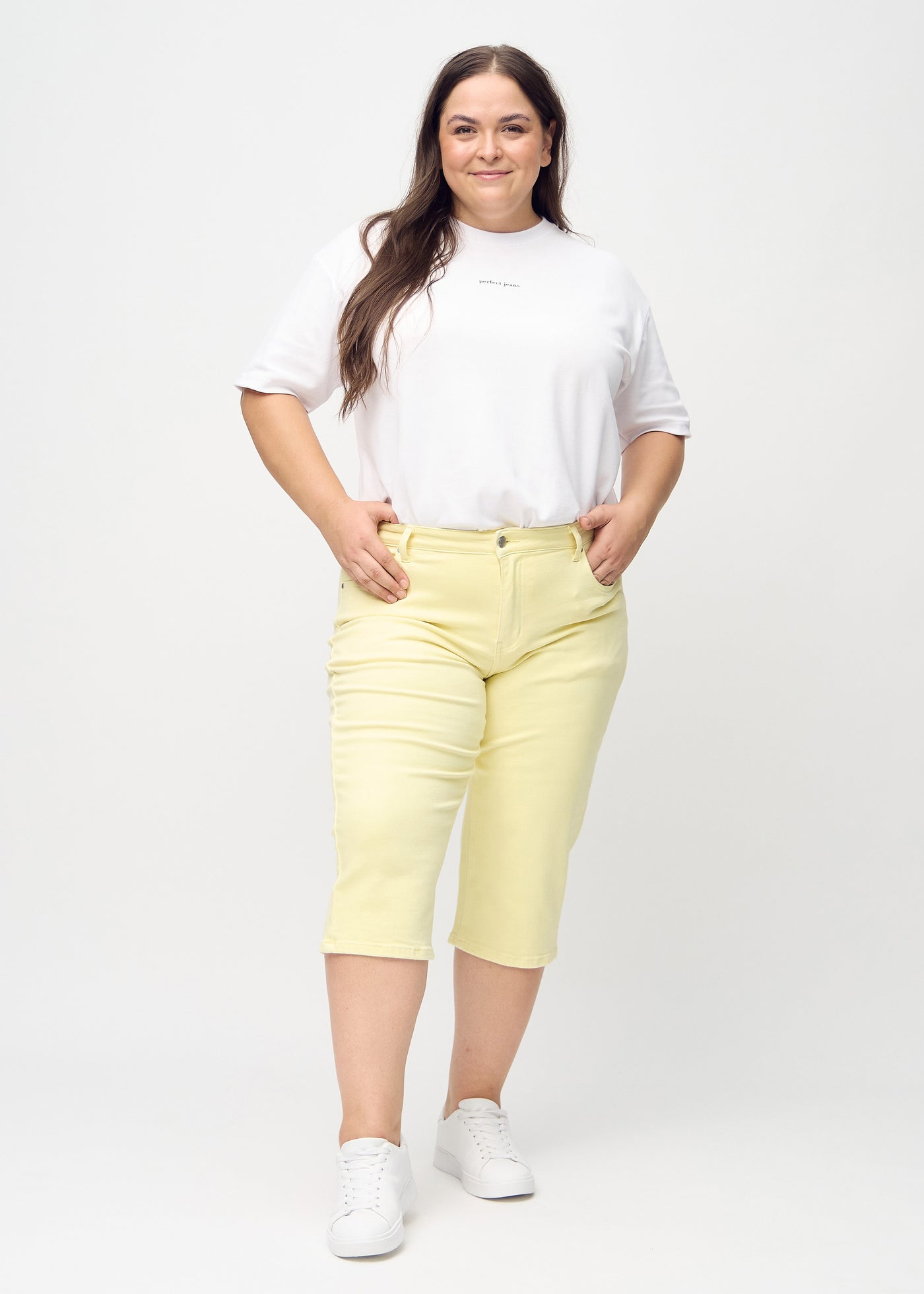Lysegule regular capris set bagfra tæt på en plus-size model for at vise detaljer.