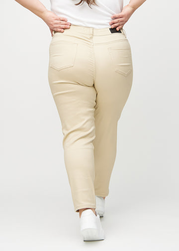 Beige slim jeans set bagfra på en plus-size model, så man kan se hele produktet.