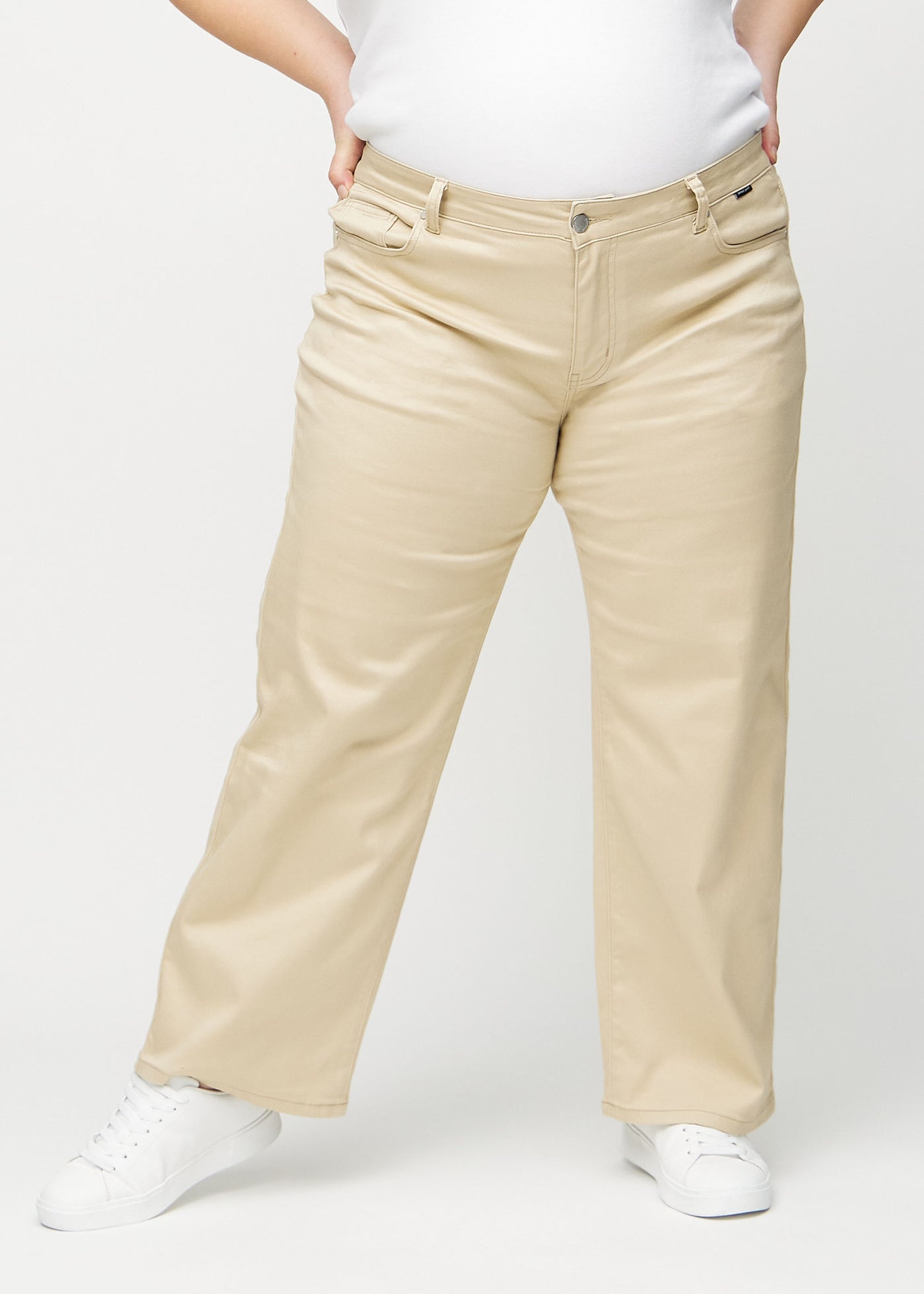 Beige loose jeans, modelnavn Gazelles, som er løstsiddende med masser af vidde i benene på en plus-size model, set forfra.