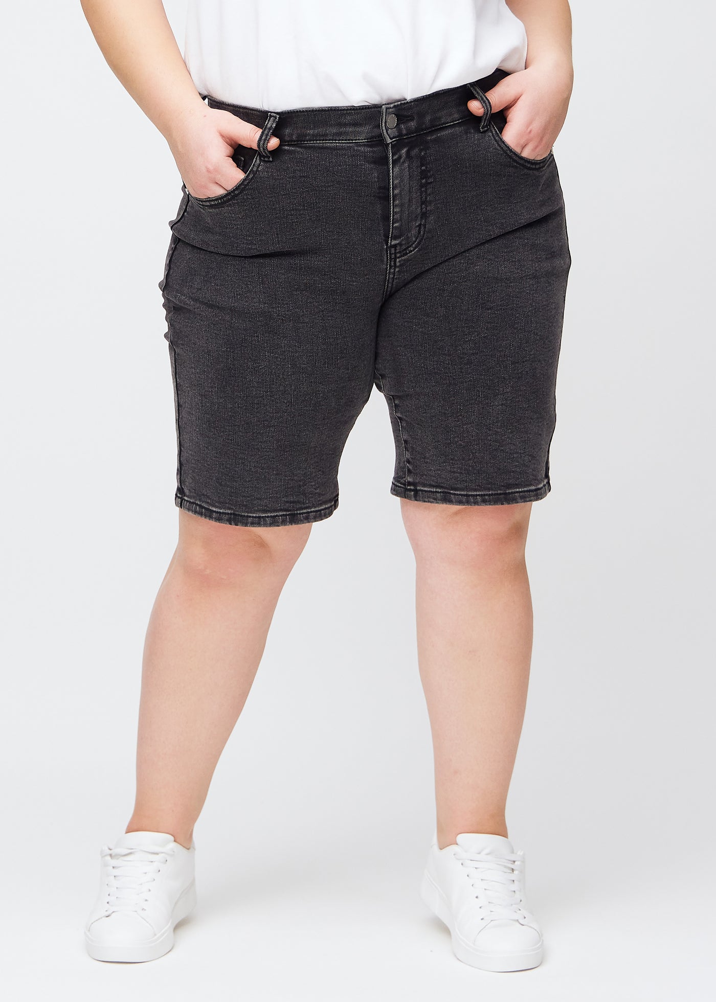 Mørkegrå denim regular middle shorts, modelnavn Shadows, som går lige ned langs benet og slutter lige over knæet på en plus-size model, set forfra.
