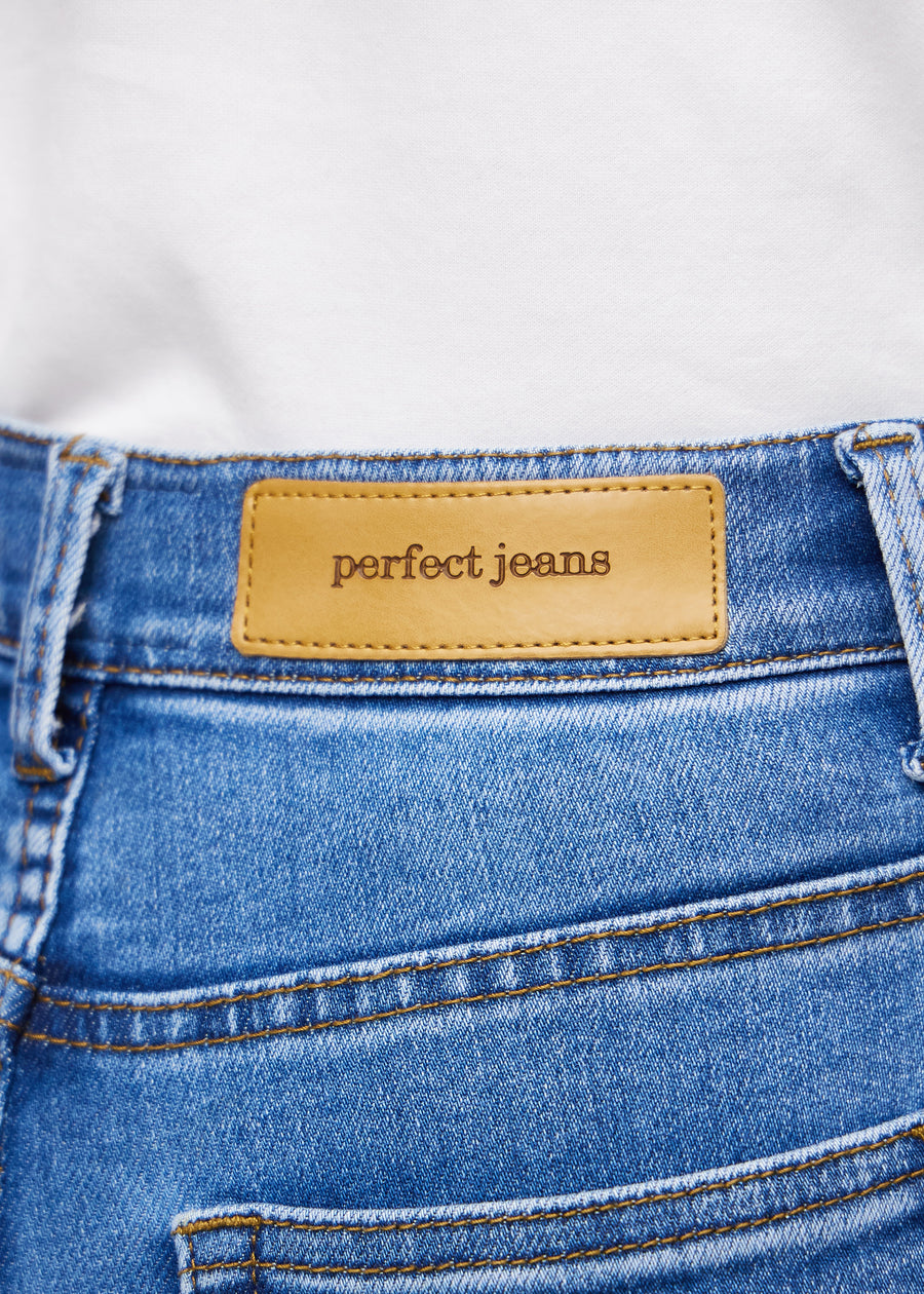 Nærbilde av blå denim med Perfect Jeans lærpatch bak i linningen.