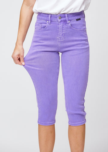 Model strækker caprisene ved låret for at vise det bløde og fleksible stretch.