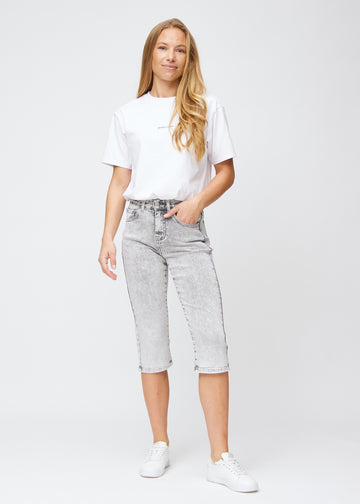 Model går ind i billedet, strækker i sine capris, viser dem frem ved at dreje rundt, og forlader derefter billedet.