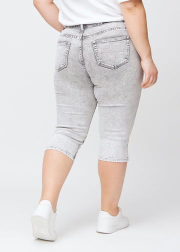 Lysegrå denim slim capris set bagfra på en plus-size model – tydeligt billede af hele produktet og lommer.