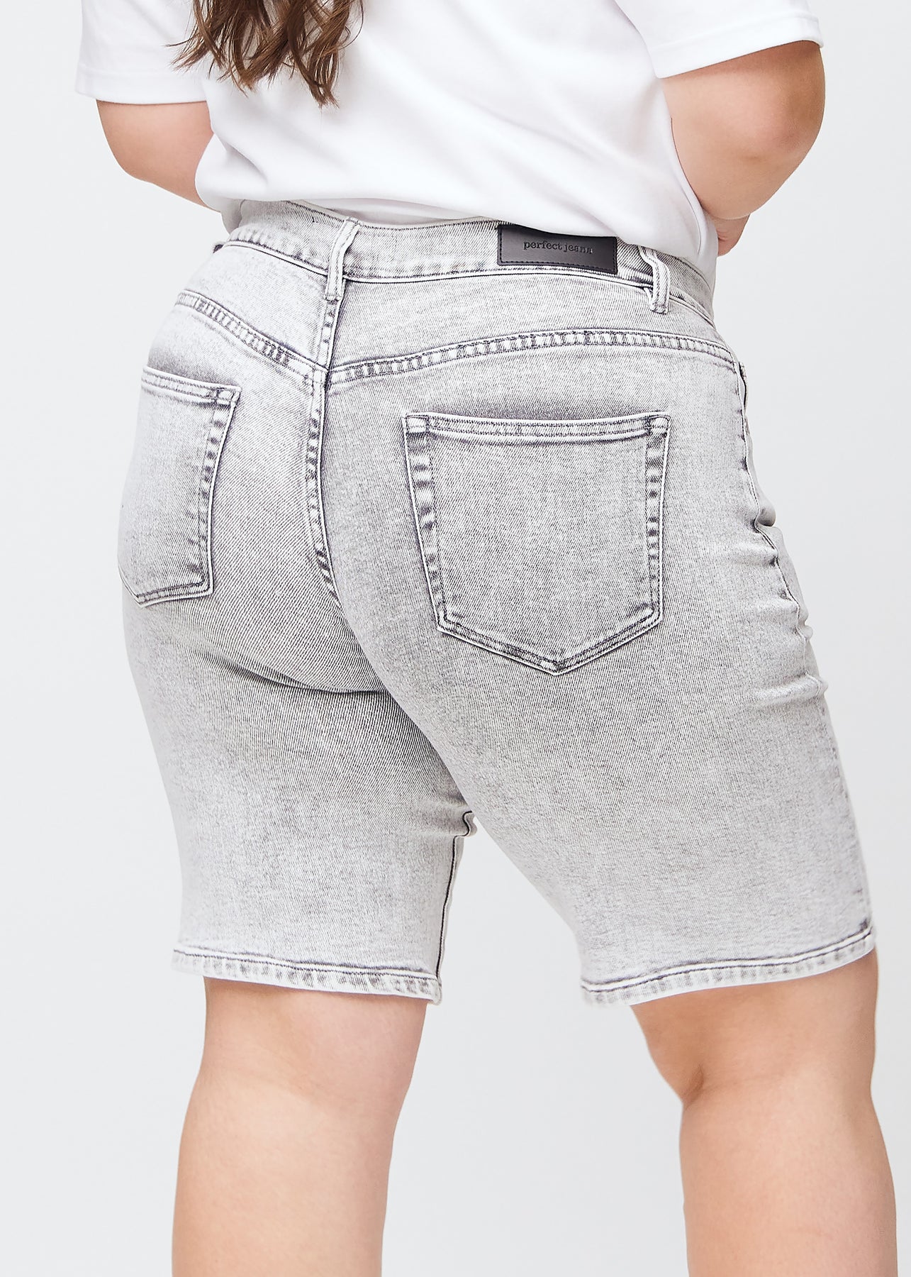 Lysegrå denim regular middle shorts set bagfra tæt på en plus-size model for at vise detaljer.