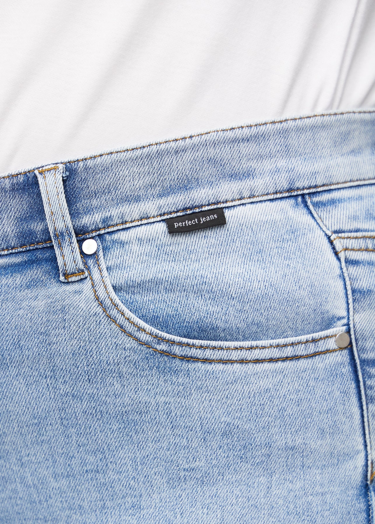 Nærbilde av lyseblå denim med Perfect Jeans skinnpatch bak i livet.