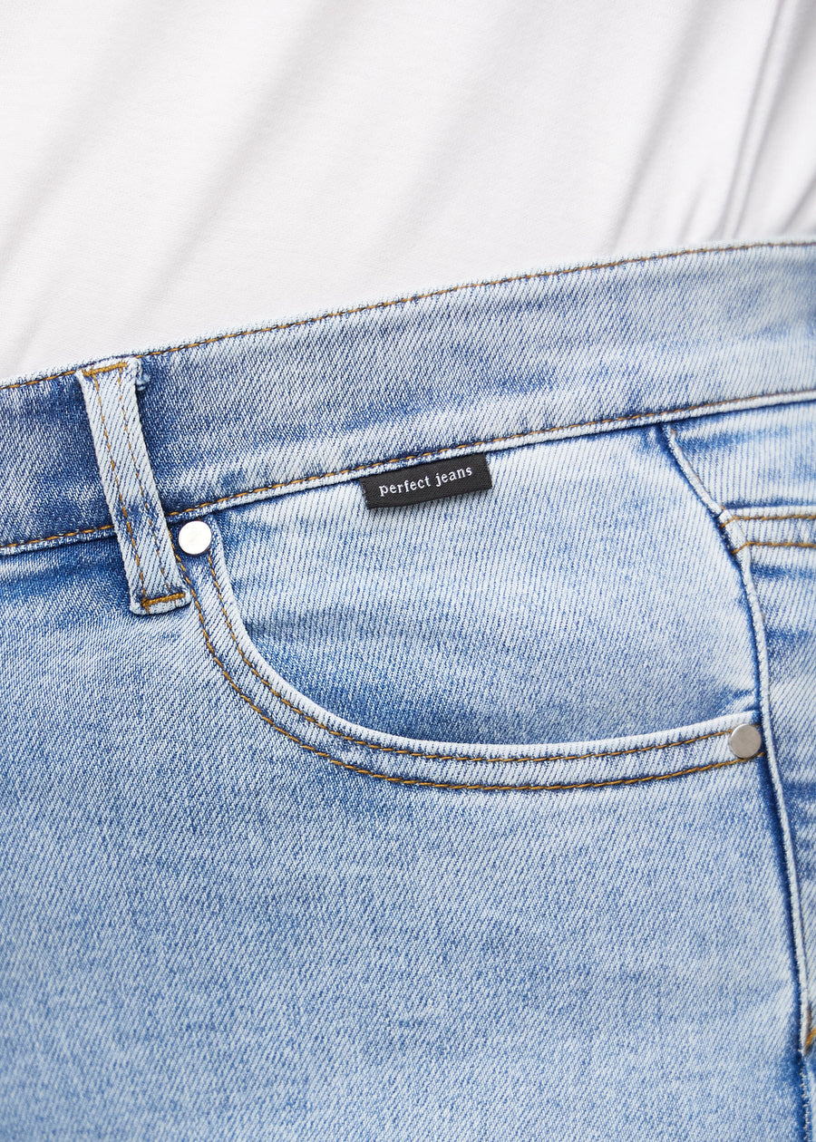 Nærbilde av lyseblå denim med Perfect Jeans skinnpatch bak i livet.