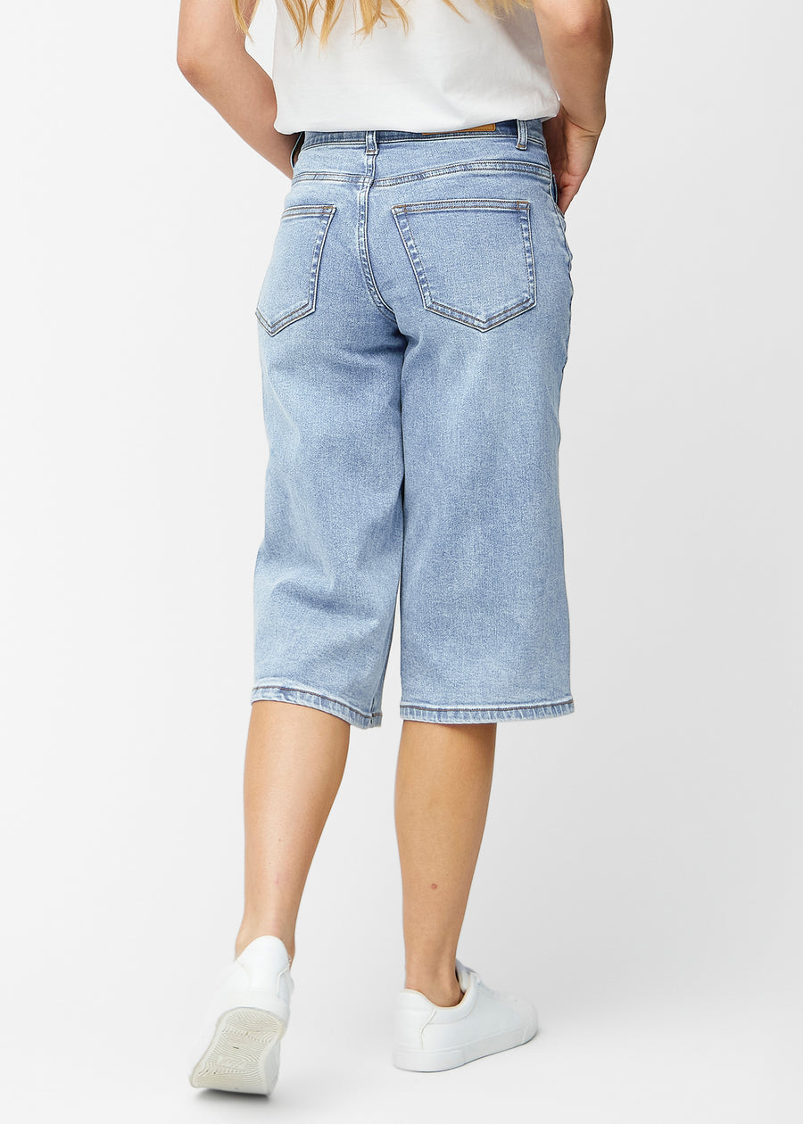 Løse, lyseblå denim capris i fargen Waves sett bakfra, slik at passform og lengde kan sees.