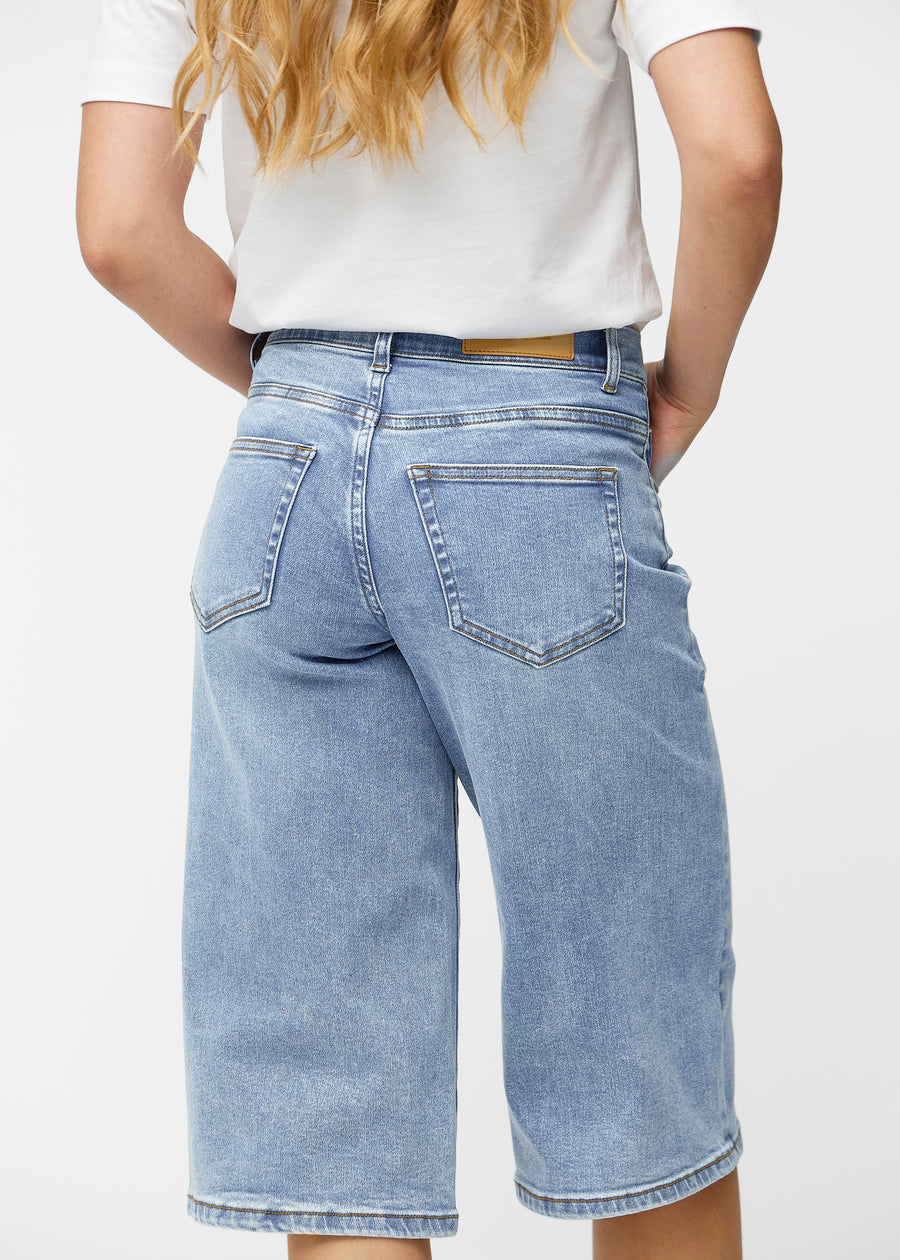 Løse, lyseblå denim capris i fargen Waves sett bakfra på nært hold for å vise passform og detaljer.