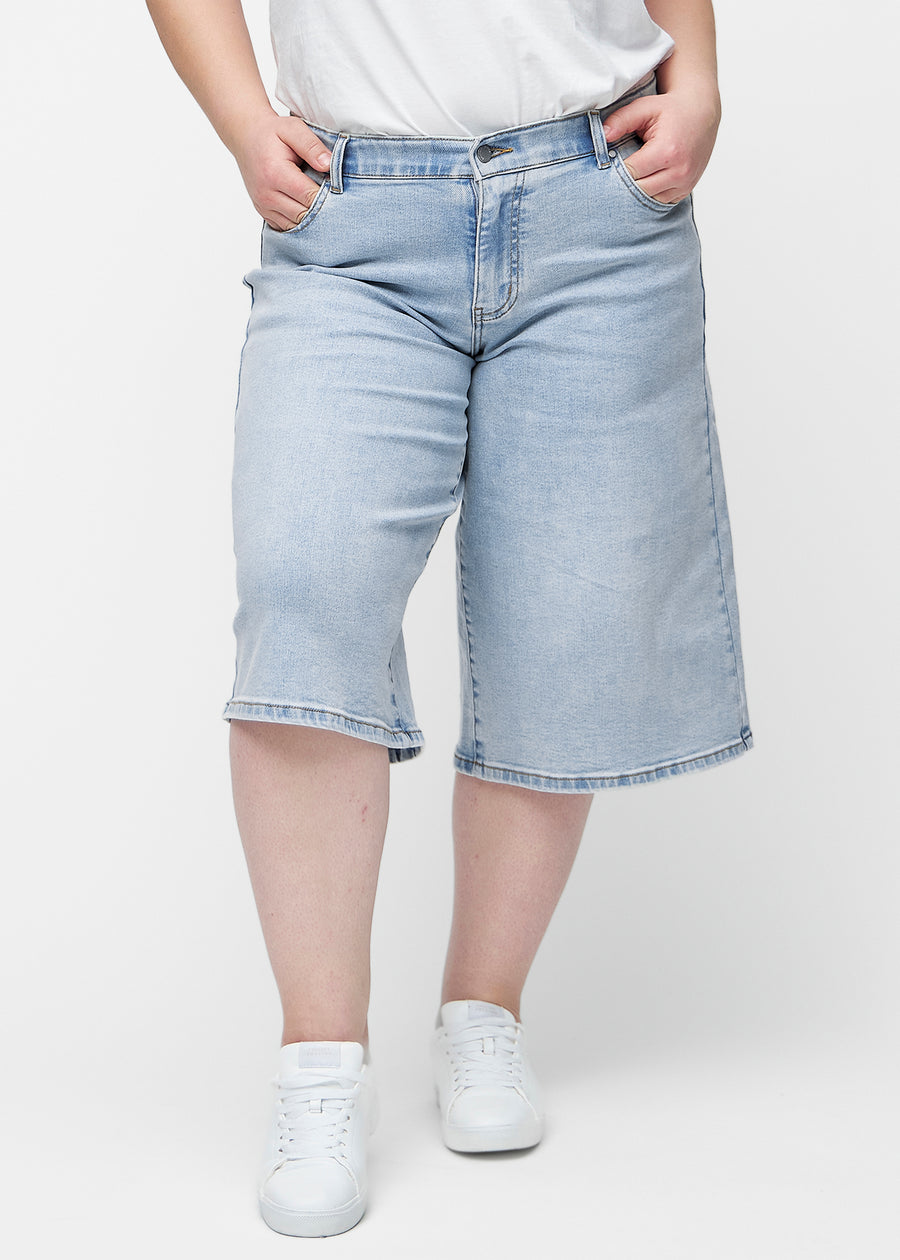 Løse, lyseblå denim capris i fargen Waves sett forfra på plus-size modell, som sitter ved hoften og faller løst ned.