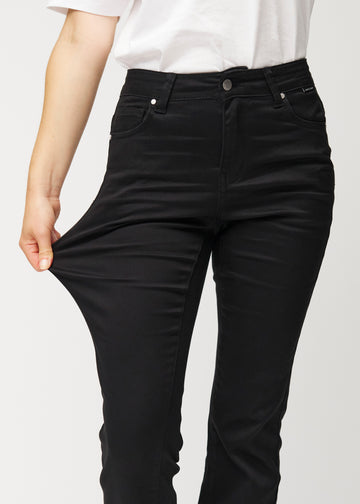 Model strækker jeansene ved låret for at vise stretch.