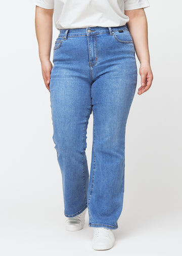 Blå mid-rise bootcut-jeans i fargen Rivers. Sett forfra på en plus size-modell, med tettsittende passform over hofter og lår og lett utsving nederst.