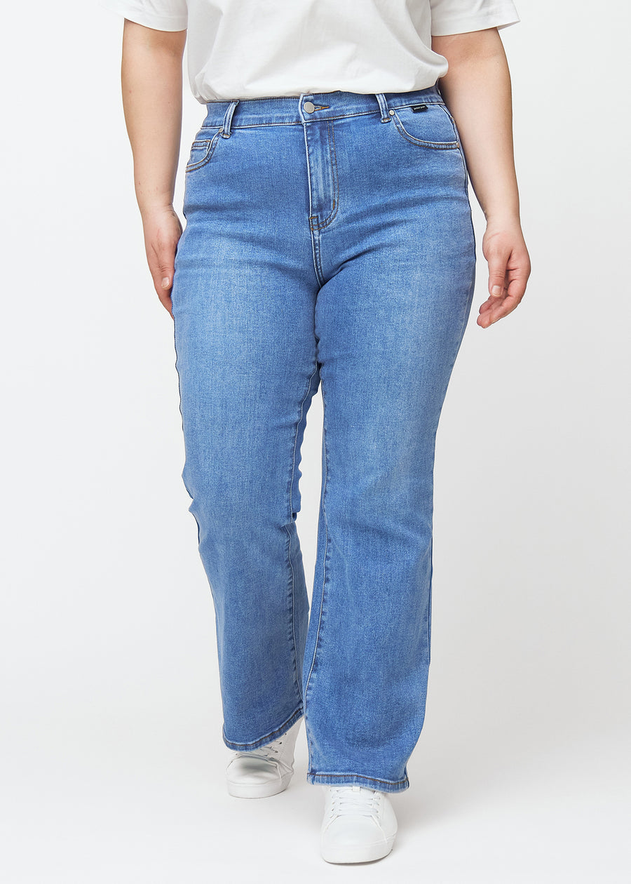 Blå mid-rise bootcut-jeans i fargen Rivers. Sett forfra på en plus size-modell, med tettsittende passform over hofter og lår og lett utsving nederst.