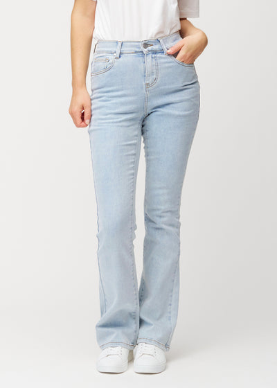 Lyseblå mid-rise bootcut-jeans i fargen Waves. Sett forfra på en modell, med tettsittende passform over hofter og lår og lett utsving nederst.