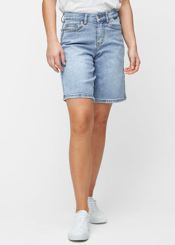 Løse, lyseblå denimshorts i fargen Waves som sitter ved hoften og faller løst ned over lårene til rett over kneet, sett forfra.