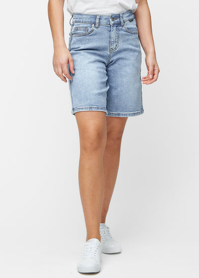 Løse, lyseblå denimshorts i fargen Waves som sitter ved hoften og faller løst ned over lårene til rett over kneet, sett forfra.