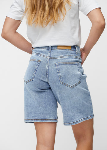 Løse, lyseblå denimshorts i fargen Waves sett bakfra på nært hold for å vise passform og detaljer.