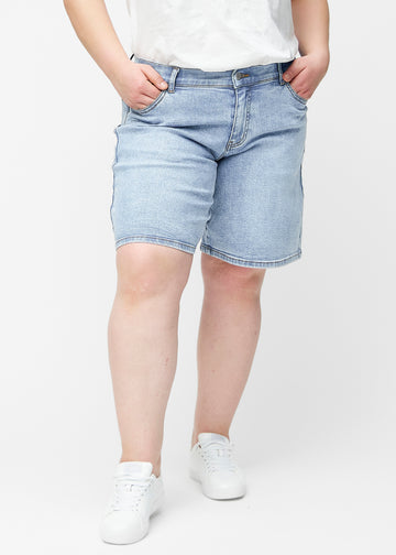 Løse, lyseblå denimshorts i fargen Waves sett forfra på plus-size modell, som sitter ved hoften og faller løst ned.