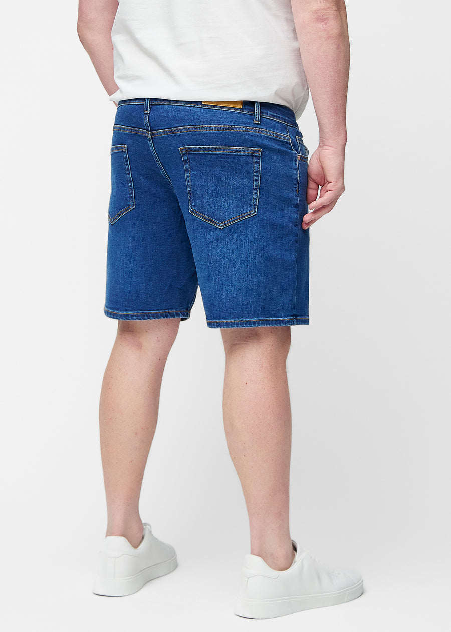 Mørkeblå denimshorts til herre i fargen Oceans sett bakfra på plus-size modell.