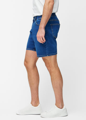 Mørkeblå denimshorts til herre i fargen Oceans med regular passform sett fra siden på modell.