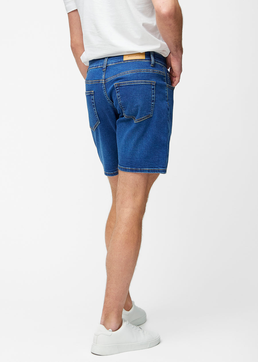 Mørkeblå denimshorts til herre i fargen Oceans sett bakfra slik at lengden til rett over kneet og passformen kan sees.