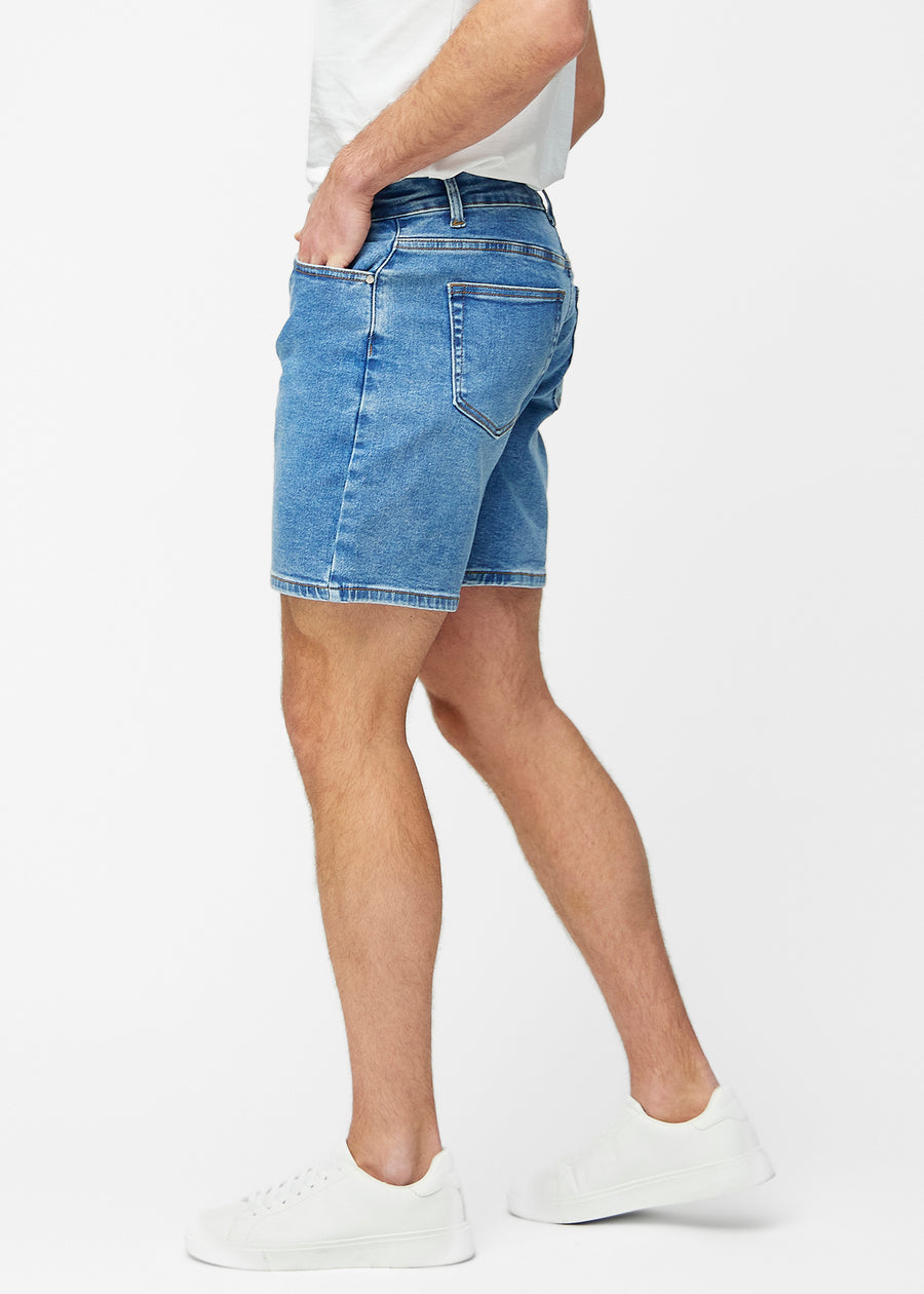 Blå denimshorts til herre i fargen Rivers med regular passform sett fra siden på modell.