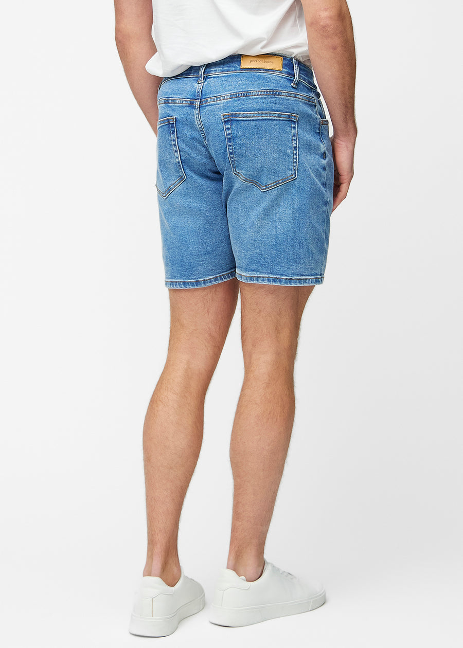 Blå denimshorts til herre i fargen Rivers sett bakfra slik at lengden til rett over kneet og passformen kan sees.