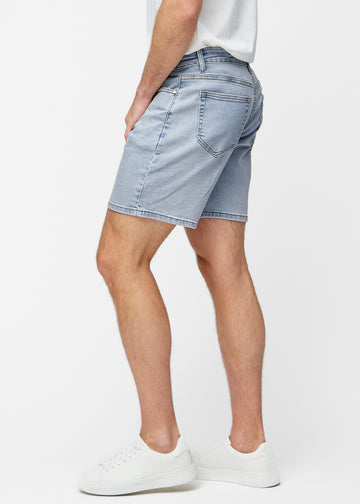 Lyseblå denimshorts til herre i fargen Waves med regular passform sett fra siden på modell.