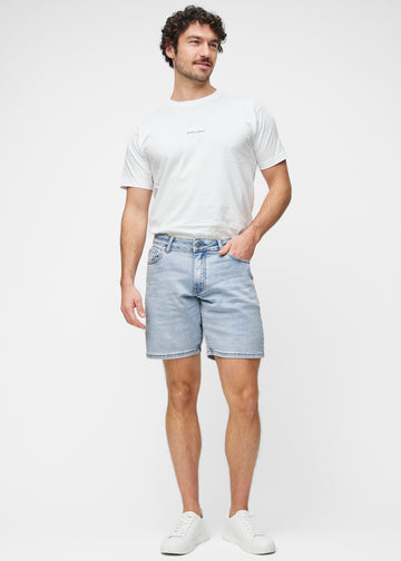 Fullt bilde av modell i lyseblå denimshorts til herre i fargen Waves med regular passform.