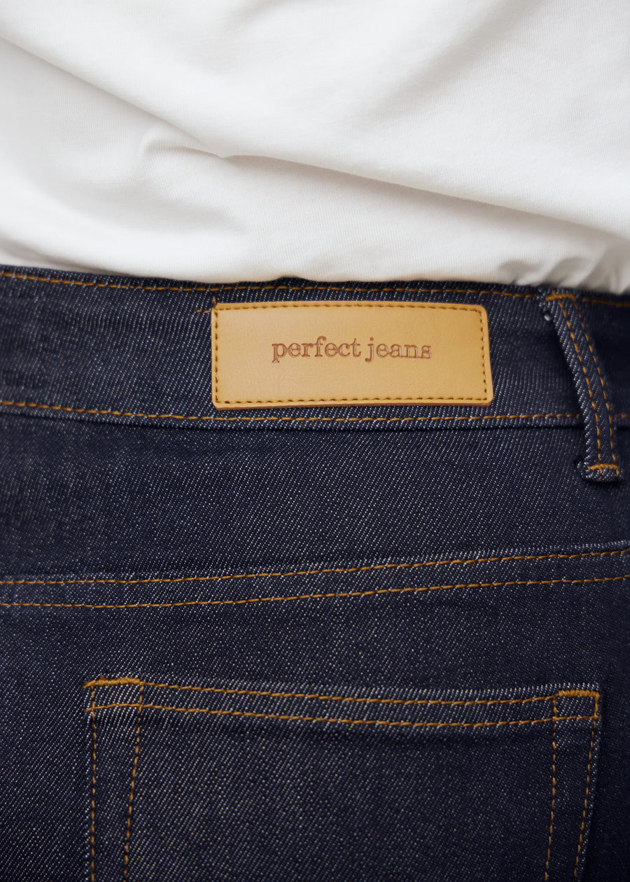 Nærbilde av dyp mørkeblå denim med Perfect Jeans lærpatch bak i midjen på plus-size modell.