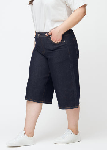 Dyp mørkeblå denim capris til dame i fargen Midnights med loose passform sett fra siden på plus-size modell.