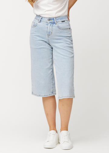 Løse, lyseblå Waves denimcapribukser som sitter inntil hoftene og faller løst over lårene til rett under kneet, sett forfra.