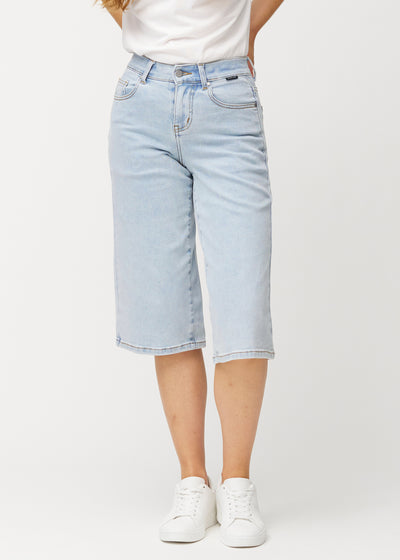 Løse, lyseblå Waves denimcapribukser som sitter inntil hoftene og faller løst over lårene til rett under kneet, sett forfra.