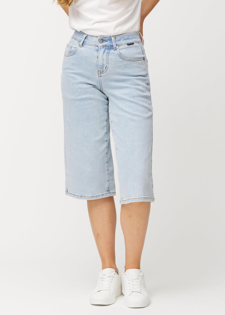 Løse, lyseblå Waves denimcapribukser som sitter inntil hoftene og faller løst over lårene til rett under kneet, sett forfra.