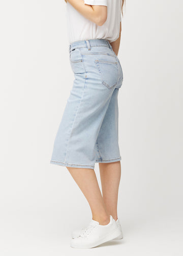 Løse, lyseblå Waves denimcapribukser sett fra siden på en modell, som viser den romslige passformen og lengden til rett under kneet.