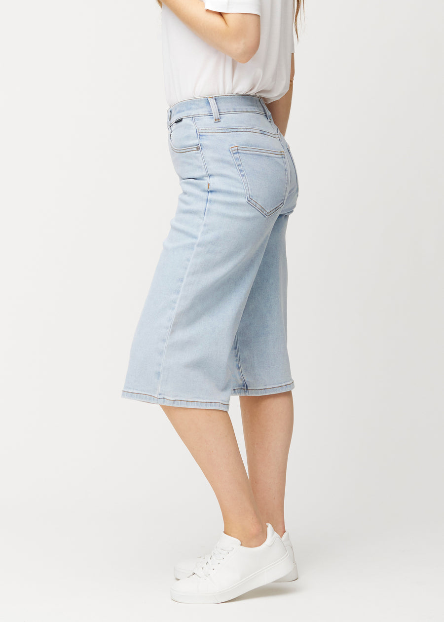 Løse, lyseblå Waves denimcapribukser sett fra siden på en modell, som viser den romslige passformen og lengden til rett under kneet.