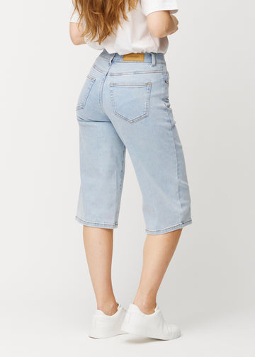 Løse, lyseblå Waves denimcapribukser sett bakfra for å vise passform og lengde.