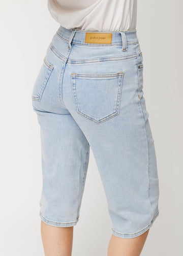 Nærbilde bakfra av løse, lyseblå Waves denimcapribukser som viser passform og detaljer.