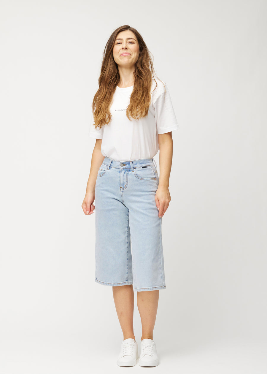 Helbilde av en modell i løse, lyseblå Waves denimcapribukser som slutter rett under kneet.