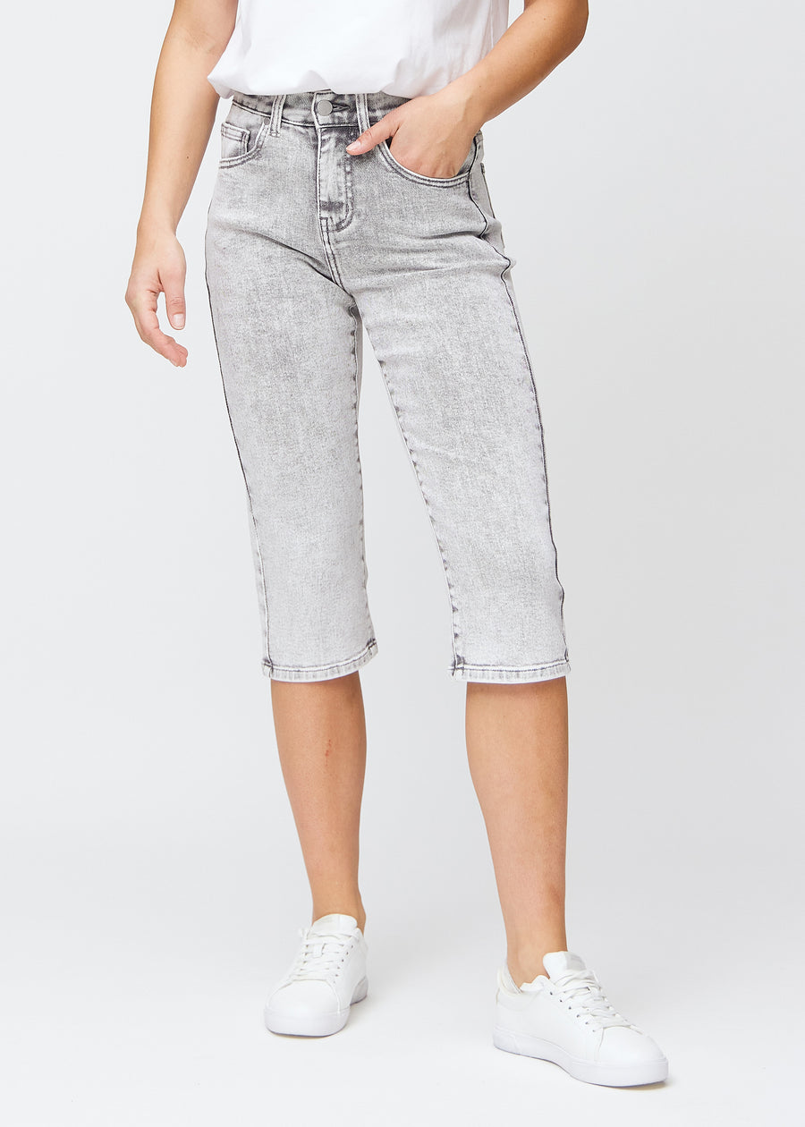 Lys grå denim regular capris, modellnavn Ashes, som sitter rett langs benet og slutter rett under kneet, sett forfra.