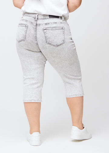 Lys grå denim regular capris sett bakfra på en plus-size-modell, så man kan se hele produktet.