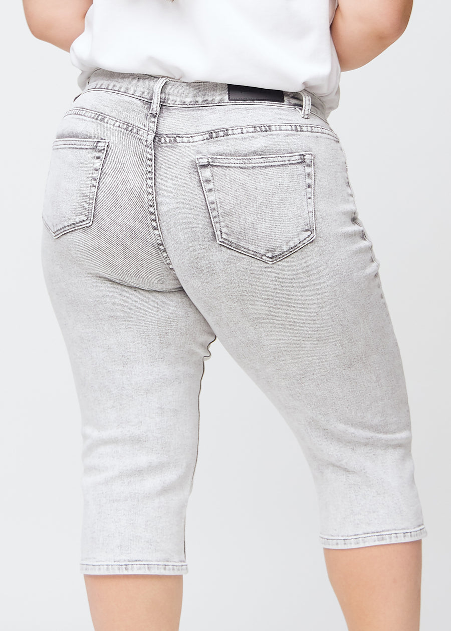 Lys grå denim regular capris sett bakfra på nært hold på en plus-size-modell for å vise detaljer.