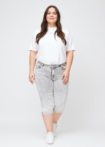 Fullt bilde av en plus-size-modell i lys grå denim regular capris.