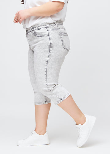 Lys grå denim regular capris sett fra siden på en plus-size-modell.
