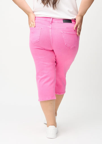Lyserosa regular capris sett bakfra på en plus-size-modell, slik at man kan se hele produktet.