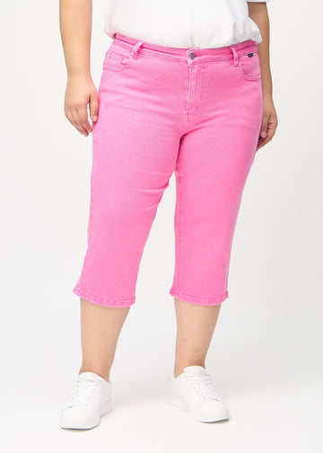 Lyserosa regular capris, modellnavn Flamingos, som går rett ned langs benet på en plus-size-modell, sett forfra.