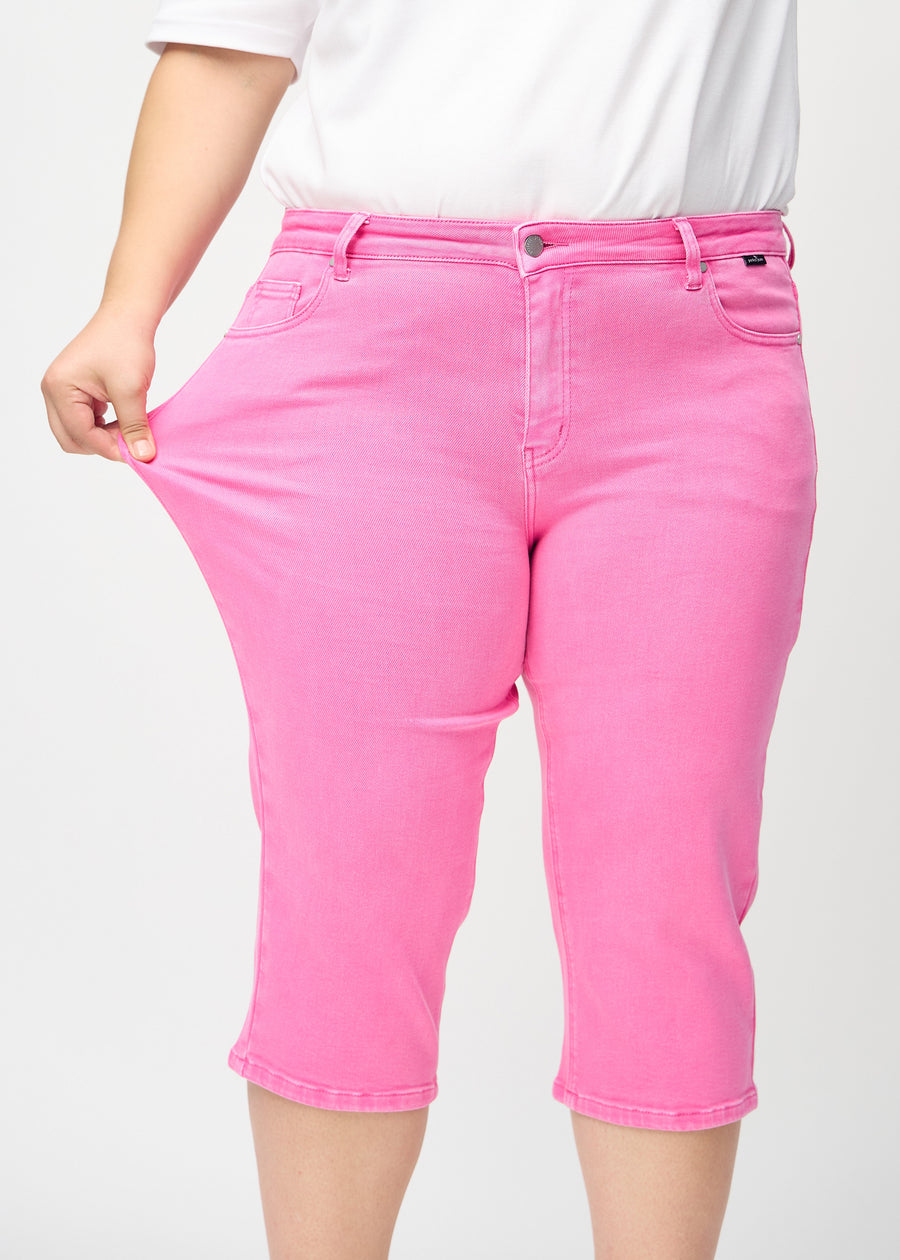 Plus-size-modellen strekker capriene ved låret for å vise stretch.