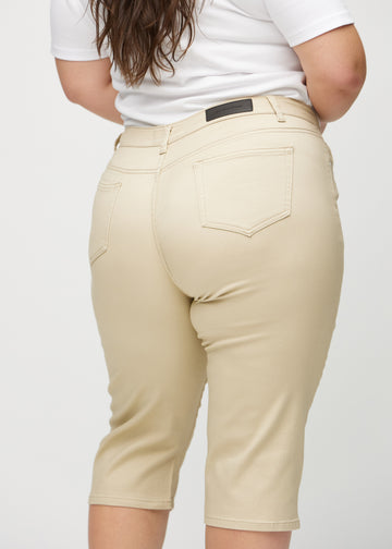 Beige regular capris sett bakfra på nært hold på en plus-size-modell for å vise detaljer.
