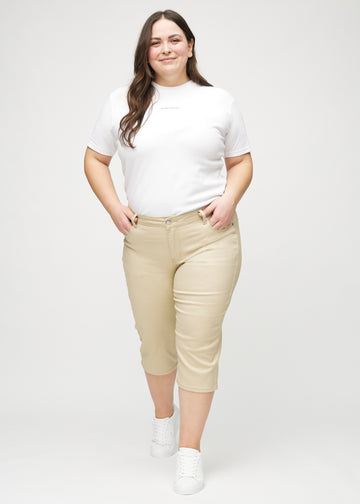 Fullt bilde av en plus-size-modell i beige regular capris.